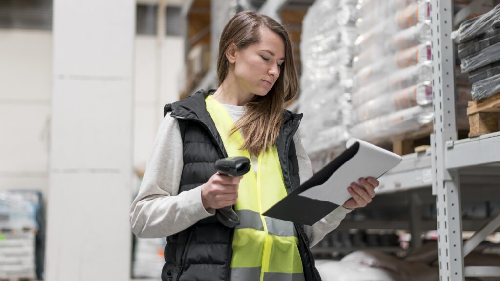 a woman holding a barcode scanner and a clipboard