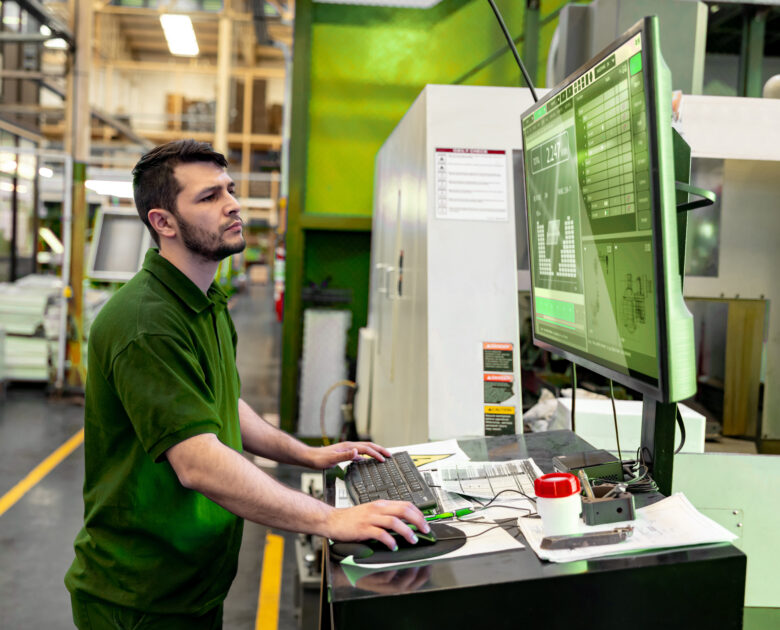 a man working on a computer in a warehouse UP TRACE connectivité