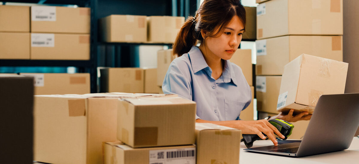 femme scannant les codes barres de cartons